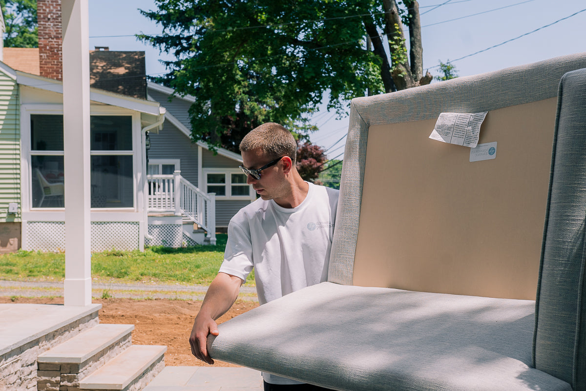 New upholstered furniture being carried toward the entrance of the home.
