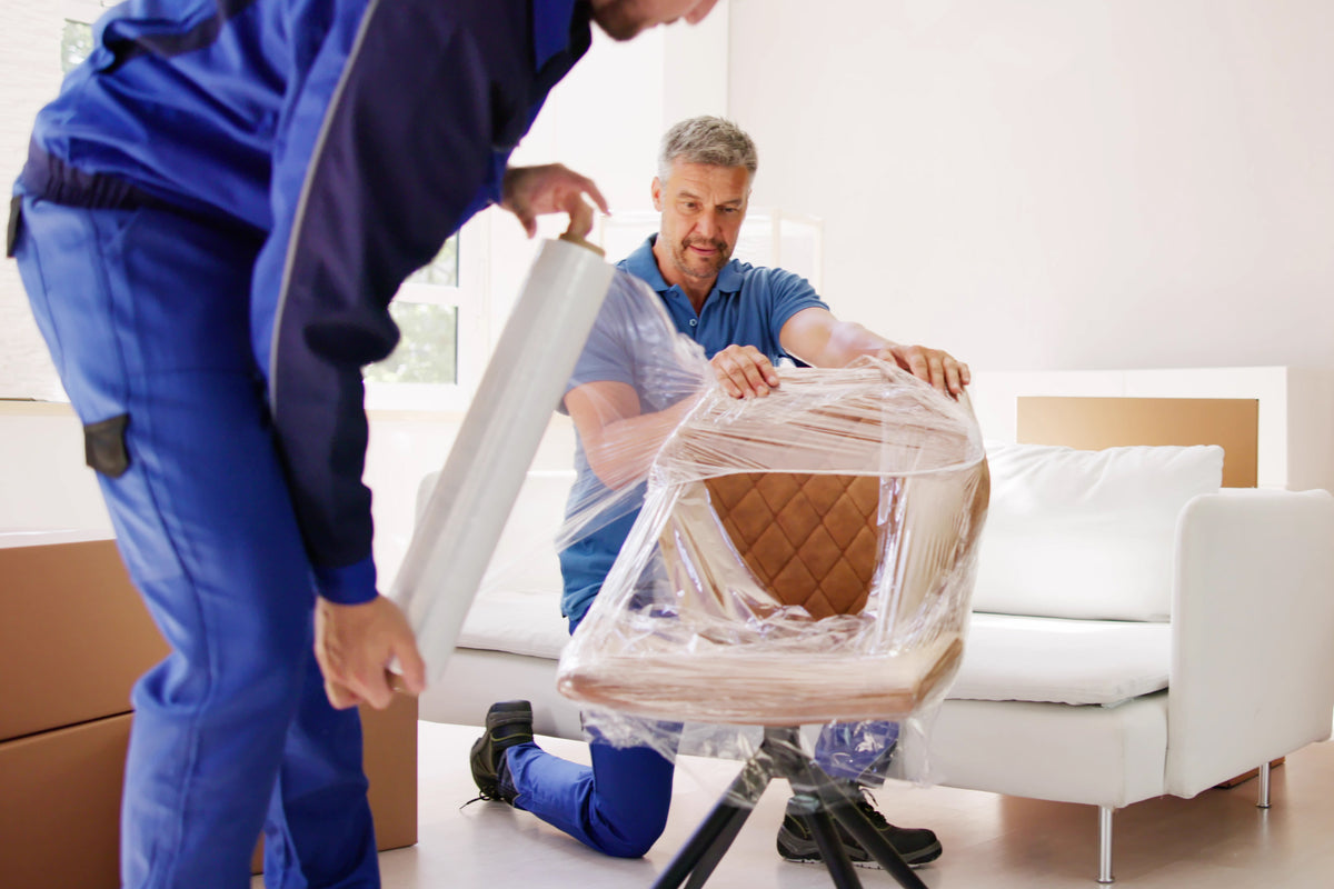 Movers wrapping and protecting furniture before a move
