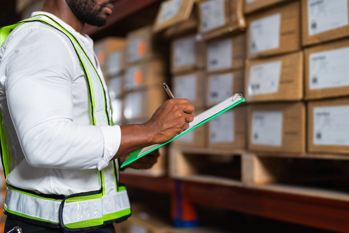 A team member reviewing a checklist beside packed boxes